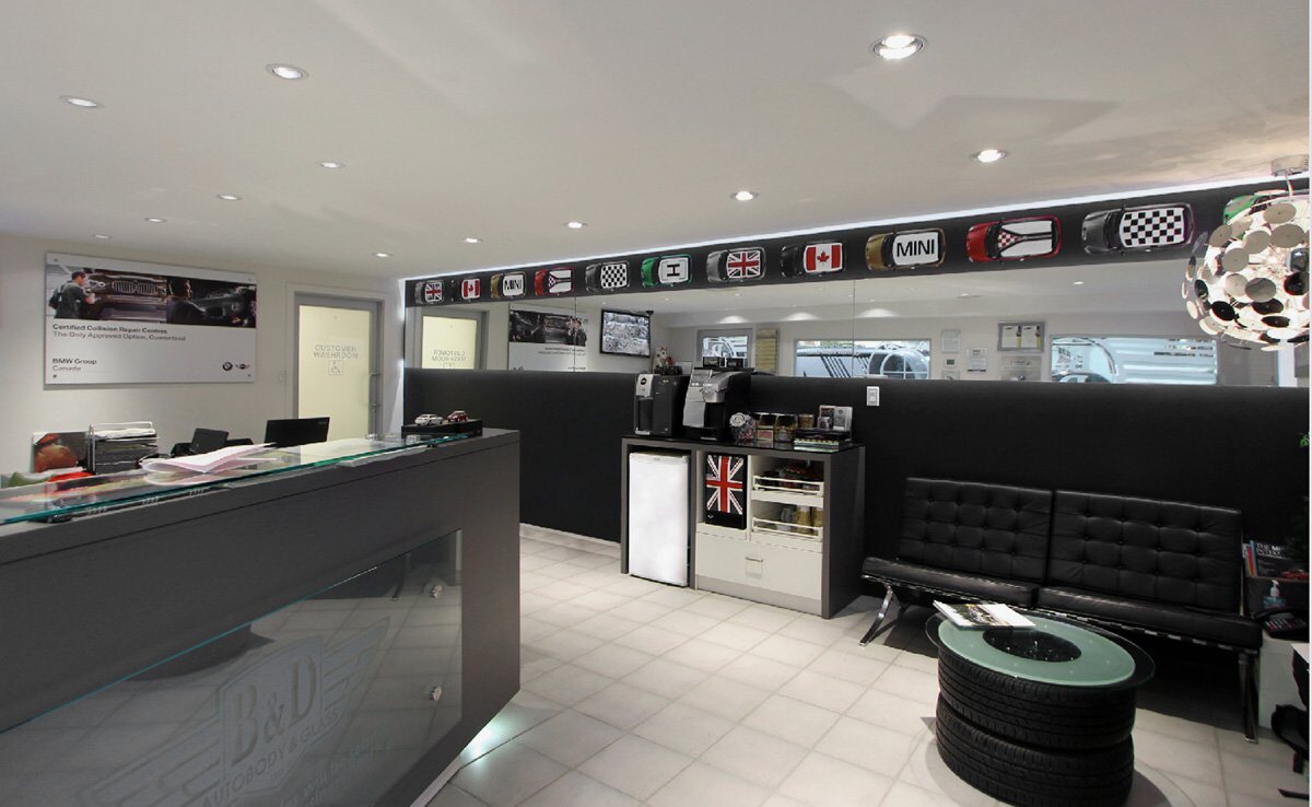B&D Autobody and Glass reception: a clean modern front counter with etched glass, customer seating, a coffee station and MINI roof decor along the wall